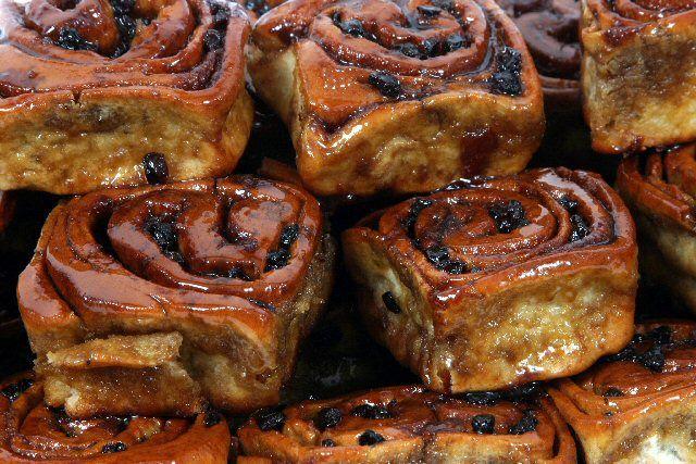 Close-up of a pile of Fitzbillies Chelsea Buns, looking sticky and golden.