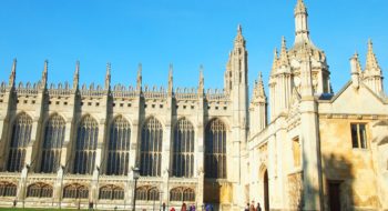 Exterior view of the magnificent King's College Chapel in Cambridge, showcasing its grand Gothic architecture under a clear blue sky.