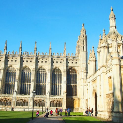 Exterior view of the magnificent King's College Chapel in Cambridge, showcasing its grand Gothic architecture under a clear blue sky.