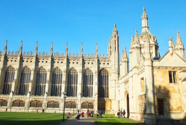 Exterior view of the magnificent King's College Chapel in Cambridge, showcasing its grand Gothic architecture under a clear blue sky.