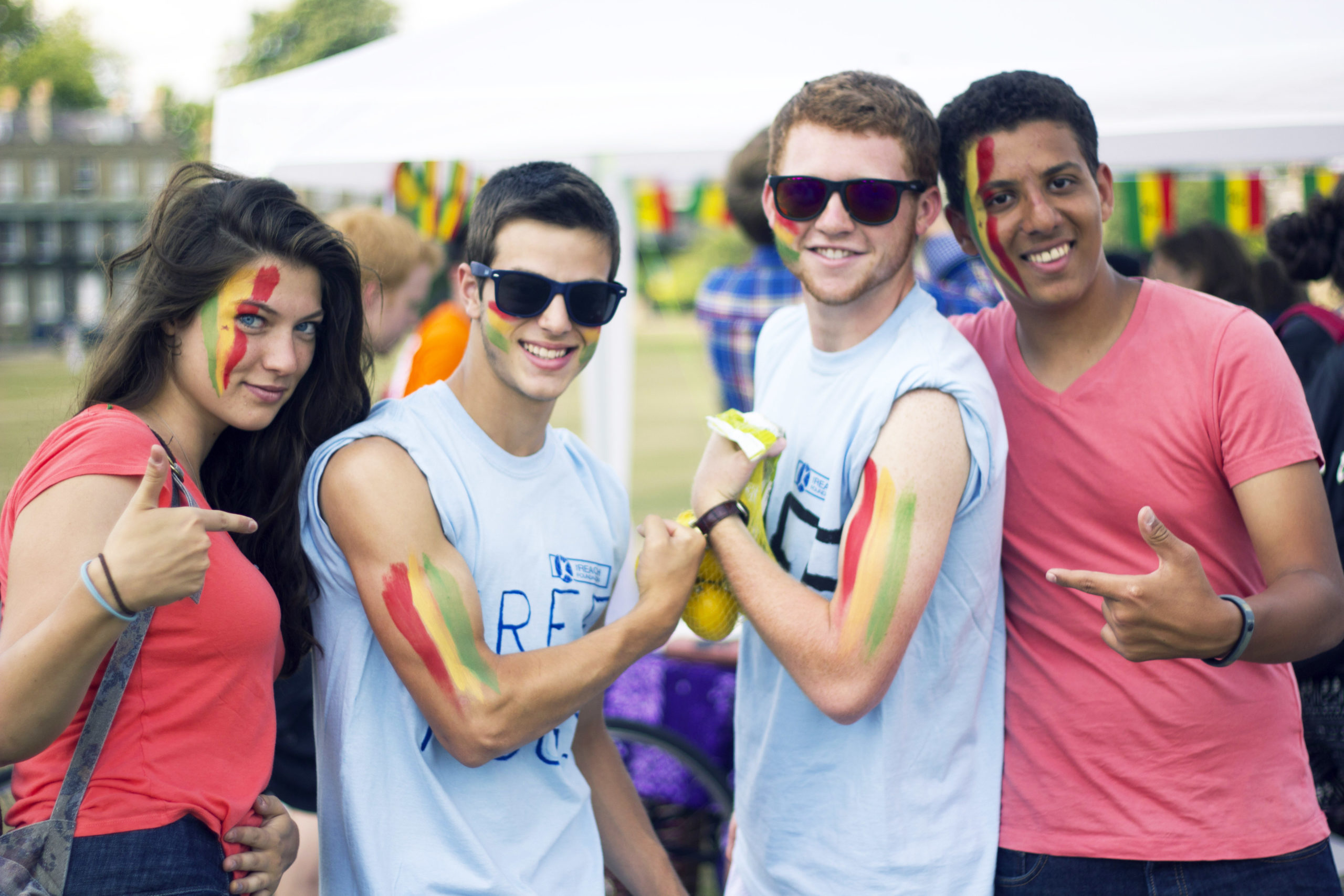 Reach Cambridge students with international flag face paint, celebrating diversity at a cultural festival.